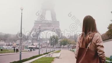 年轻快乐的女人走在巴黎埃菲尔铁塔附近，法国。游客环顾四周，微笑着。慢动作。